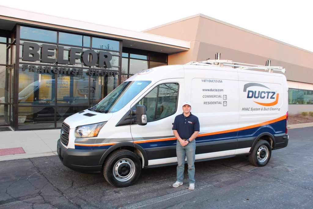 DUCTZ air duct cleaning franchise owner stands with van open a duct cleaning business